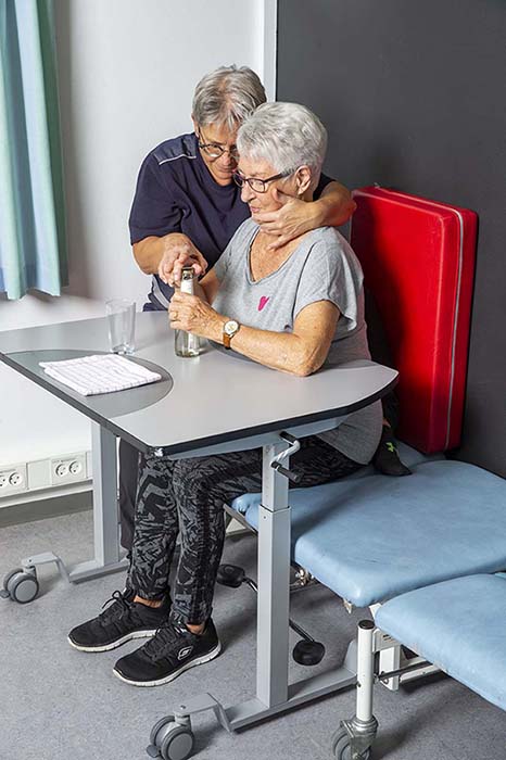 Patient seated at ErgoMulti training table during dysphagia therapy session
